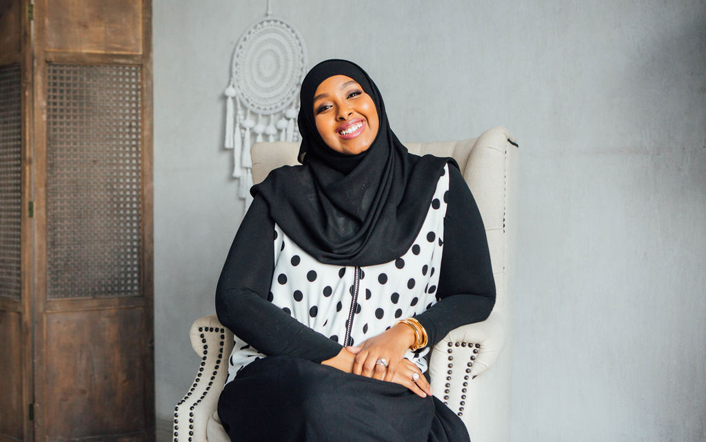 Ms. Eman smiling, seated